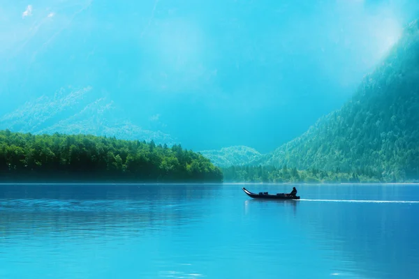 Piccola barca su un lago nelle Alpi Immagine Stock