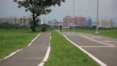 Taipei, Tayvan 'ın yaz seti parkı, mavi gökyüzü ve beyaz bulutlar, ağaçlar ve yeşil çimenler, rüzgarda sallanan ağaçlar, açık hava aktiviteleri onu iyi hissettiriyor.
