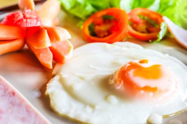 kahvaltı tabağı kızarmış yumurta, pastırma ve sosis ile