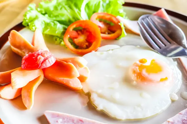 Frühstücksteller mit Spiegeleiern, Speck und Würstchen — Stockfoto
