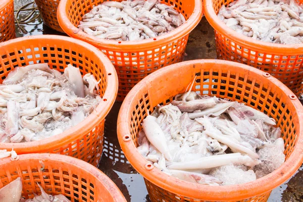 Pila di calamari freschi in cesto venduti nel mercato della piscicoltura — Foto Stock