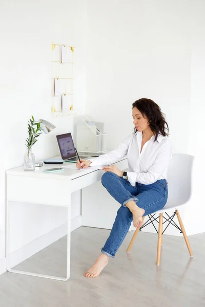 Brunette Woman White Shirt Jeans Freelancer His Desk Writes Notes — Stock Photo, Image