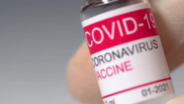 แพทย์ปิดมือถือขวดแก้วของวัคซีนไวรัสโคโรนา แนวคิดของการฉีดวัคซีนป้องกันไวรัสโคโรนา แมคโคร 4k — วีดีโอสต็อก