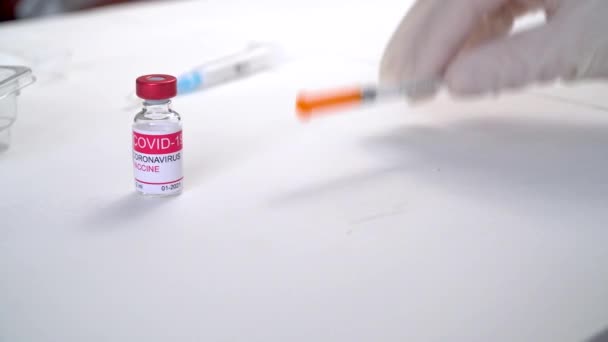 Doktorlar eldiven takıp Coronavirus aşısı ve şırınga şişelerini alıyorlar. — Stok video