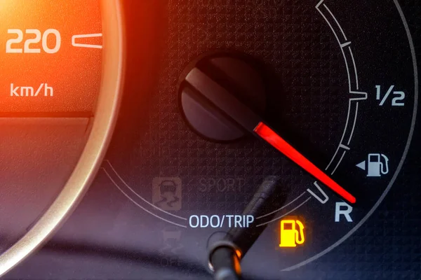 The indicator in the car on the dashboard warns of low fuel level.