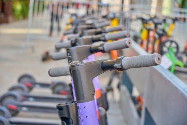 Şehrin caddesinde park halindeki elektrikli scooterları kiraladım..