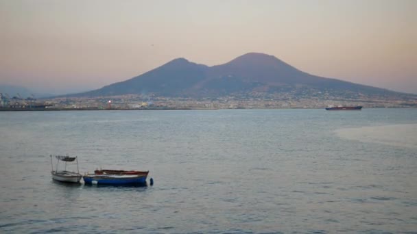 Старі човни на передньому плані і Везувій на горизонті в Неаполі. — стокове відео
