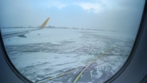 Вид из окна самолета "Пегас" на взлетно-посадочную полосу в снежном аэропорту — стоковое видео