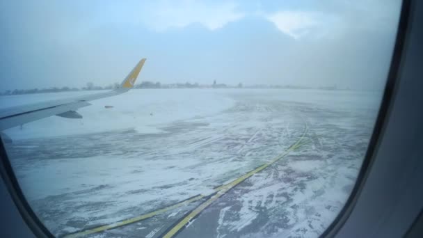 Utsikt från Pegasus flygplansfönster på den snöiga startlandningsbanan - Tilt — Stockvideo