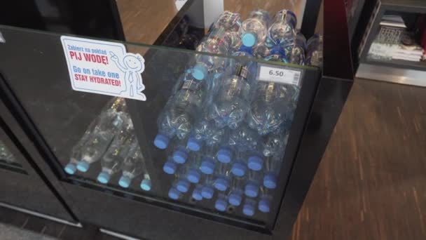 Чистая вода бутылки в витрине перед магазином беспошлинной торговли в аэропорту Коперника Вроцлав - Пан справа, 4K — стоковое видео
