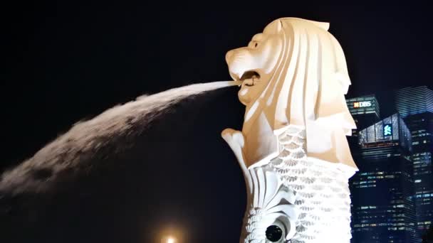 Verlichte Merlion fontein en modern gebouw op de achtergrond in Singapore — Stockvideo