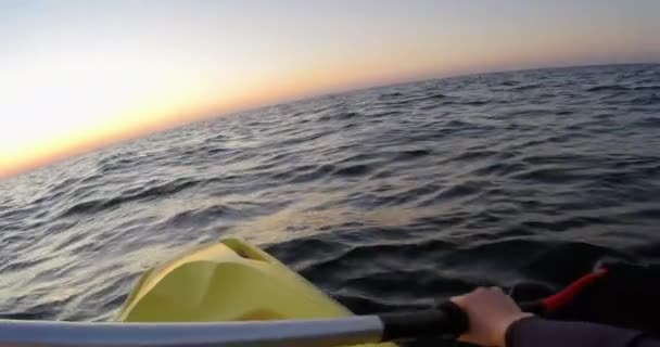 Женщина гребёт на каяке в море на рассвете - POV, Wide, DCI 4K — стоковое видео