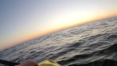 Hands and paddle during kayaking in the sea at sunrise - POV, Dutch angle, Wide, 4K