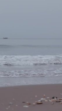 Bulutlu güneşin doğuşunu seyret Portobello Sahili üzerinde yumuşak bir parıltı yayıyor, kıyıya vuran sakin dalgaları vurguluyor..