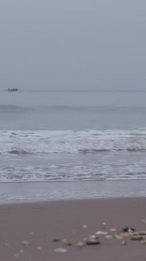 Bulutlu güneşin doğuşunu seyret Portobello Sahili üzerinde yumuşak bir parıltı yayıyor, kıyıya vuran sakin dalgaları vurguluyor..