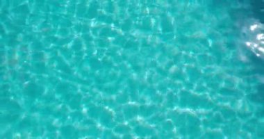 PORTOCOLOM, MALLORCA, İSPA - ECTOBER 2025: Yüzme havuzuna yakın, güneş ışığı yüzeyde yansıyor güzel dalgalar yaratıyor, yaz, dinlenme ve tatil için mükemmel bir zemin.