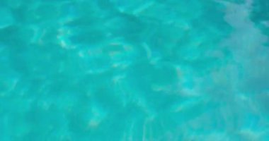 PORTOCOLOM, MALLORCA, İSPA - ECTOBER, 2025: Temiz mavi havuz suyu güneş ışığını yansıtır, parlak bir günde dalgalanmalara ve kırılmalara neden olur, rahatlatıcı bir arka plan.