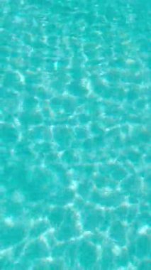 PORTOCOLOM, MALLORCA, İSPA - ECTOBER, 2025: Yüzme havuzunda güneş ışığı dansı yapar, yaz tatili havasını rahatlatır, arka plan için idealdir.