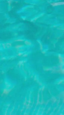 PORTOCOLOM, MALLORCA, İSPA - ECTOBER, 2025: Temiz mavi havuz suyu güneş ışığını yansıtır, parlak bir günde dalgalanmalara ve kırılmalara neden olur, rahatlatıcı bir arka plan.