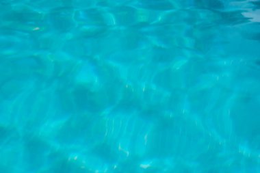 Sakin, berrak, güneş yansıtan ve parıldayan dalgalar yaratan mavi bir su. Yaz tatili ya da huzurlu bir tatil reklamı için mükemmel..