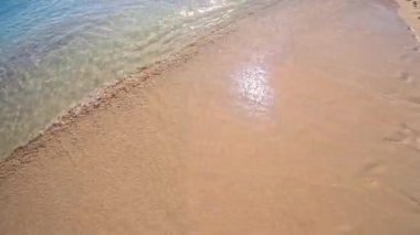 PORTOCOLOM, MALLORCA, İSPAN - 25 Ekim 2025: sakin dalgalar altın kuma hafifçe dokunur, geniş arkaplan çekimi. İspanya 'nın Mallorca plajında güneşli sakin bir gün. Ağır çekim için kullanılabilir..