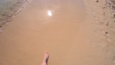 PORTOCOLOM, MALLORCA, İSPA - 25 EKİM 2025: Kumlu sahilde yürüyen kişi, geniş açılı, sadece ayakları karede. Arka planda Akdeniz görülür. Ağır çekim için kullanılabilir..