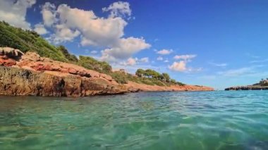 PORTOCOLOM, MALLORCA, İSPA - 22 Ekim 2025: Akdeniz 'in kayalık kıyı şeridi yakınlarındaki turkuaz suda dalgalar dalgalanır.