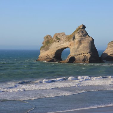 Wharariki Plajı'nda büyük bir delik ile ada