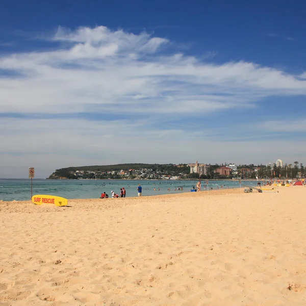 Yellow surf rescue board and sand beach in Manly, Australia.