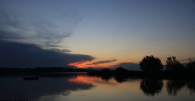 Auslikon, Wetzikon 'dan gün batımı manzarası. Parlak kırmızı gökyüzü ve Pfaeffikon Gölü kıyısı, Zürih Kantonu, İsviçre.
