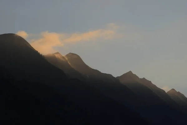 Sun lit fog over peaks of the Brienzer Rothorn mountain ridge.