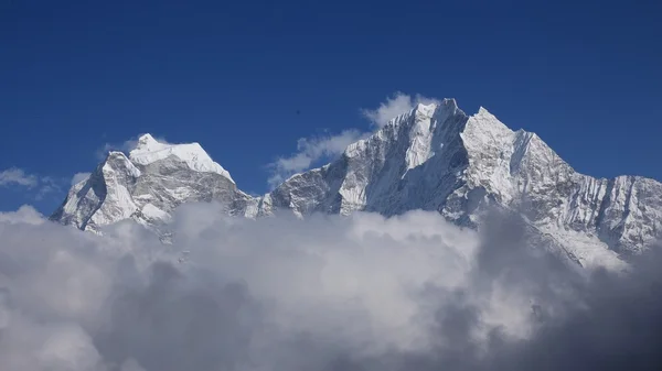 Altas montañas Thamseku y Kangtega rodeadas de nubes — Foto de Stock