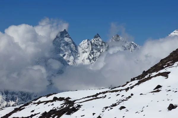 Picos de montanha no Vale de Gokyo atingindo um monte de nuvens — Fotografia de Stock