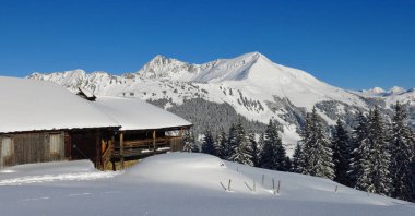 Kışın eski kereste çiftlik evi ve dağlar Gifer ve Lauenehore, Wispile, Gstaad manzarası.