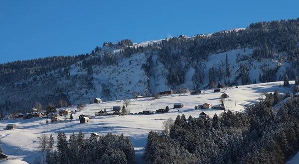 Schwendi en invierno, pequeño pueblo en los Alpes suizos — Foto de Stock