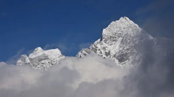 Pico do Monte Thamserku cercado por nuvens — Fotografia de Stock