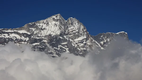 Bulutun içinden ulaşan Himalayaların yüksek dağın — Stok fotoğraf