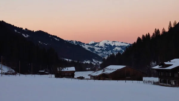 Gstaad yakınındaki kışlık manzara üzerinde pembe gökyüzü — Stok fotoğraf