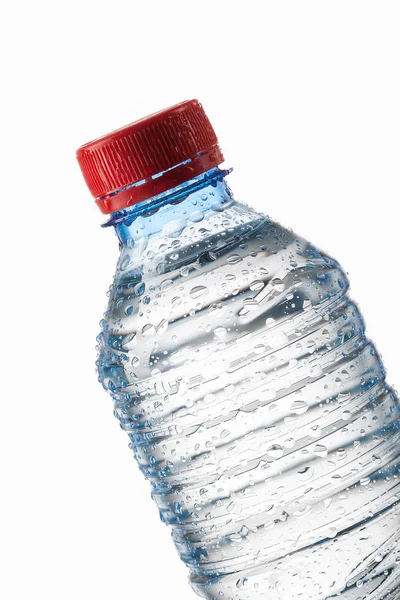 Acqua. Piccola bottiglia d'acqua di plastica con gocce d'acqua sul retro bianco — Foto Stock