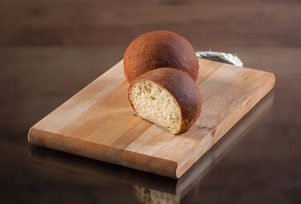 Voedsel. Vers gebakken brood op brood bord met houten textuur — Stockfoto