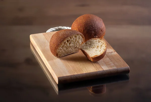 Voedsel. Vers gebakken brood op brood bord met houten textuur — Stockfoto