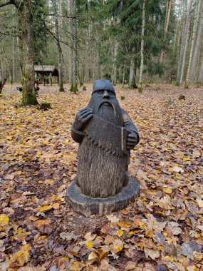 Letonya 'daki Tervete Ulusal Parkı' nda tahta cüce figürü. Sihirli ormanda peri masalı biblosu.