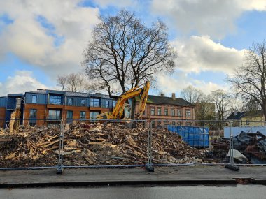 Kazı makinesiyle ev yıkımı. Buldozer eski bir binayı eziyor.. 