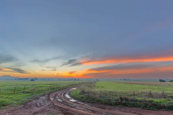 Puesta de sol sobre el camino fangoso —  Fotos de Stock