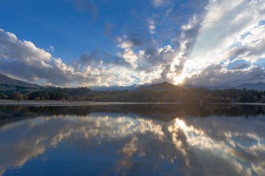 Güneş gün batımında bulutların arasında parlıyor.