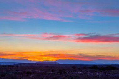 Karoo 'da gün batımından sonra pembe ve sarı renkli bulutlar