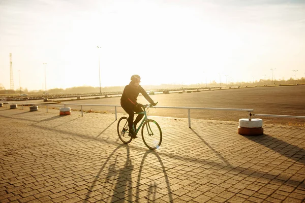 cyclist in black clothes and helmet trains on a bicycle