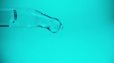 Bir pipetten bir damla su veya yağ damlıyor, yakın plan. İlaç, ilaç, kozmetik kavramı. Tam HD.