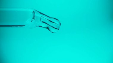 Bir pipetten bir damla su veya yağ damlıyor, yakın plan. İlaç, ilaç, kozmetik kavramı. Tam HD.