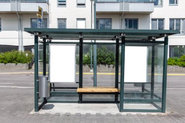Şehir caddesindeki otobüs durağında iki tane dikey beyaz ilan panosu var. Arka plandaki binalarda ve yolda. Model yap. Güneşli yaz gününde poster.